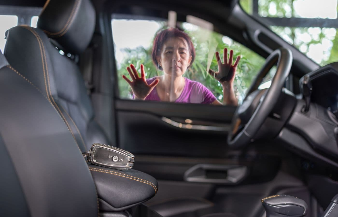 Mujer preocupada al ver sus llaves dentro del auto cerrado. Servicio de cerrajero automotriz a domicilio en Rosarito para apertura de autos sin daños.